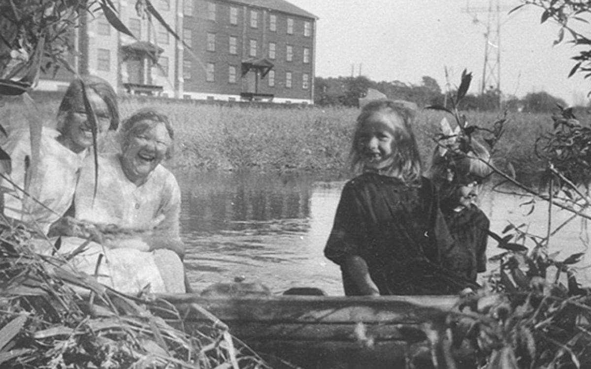 En färd på Mölndalsån 1927. Systrarna Elin och Gertrud Andersson med syskonbarnen Sonja och Aina Rundberg sitter i en båt vid Mölndalsåns strand.