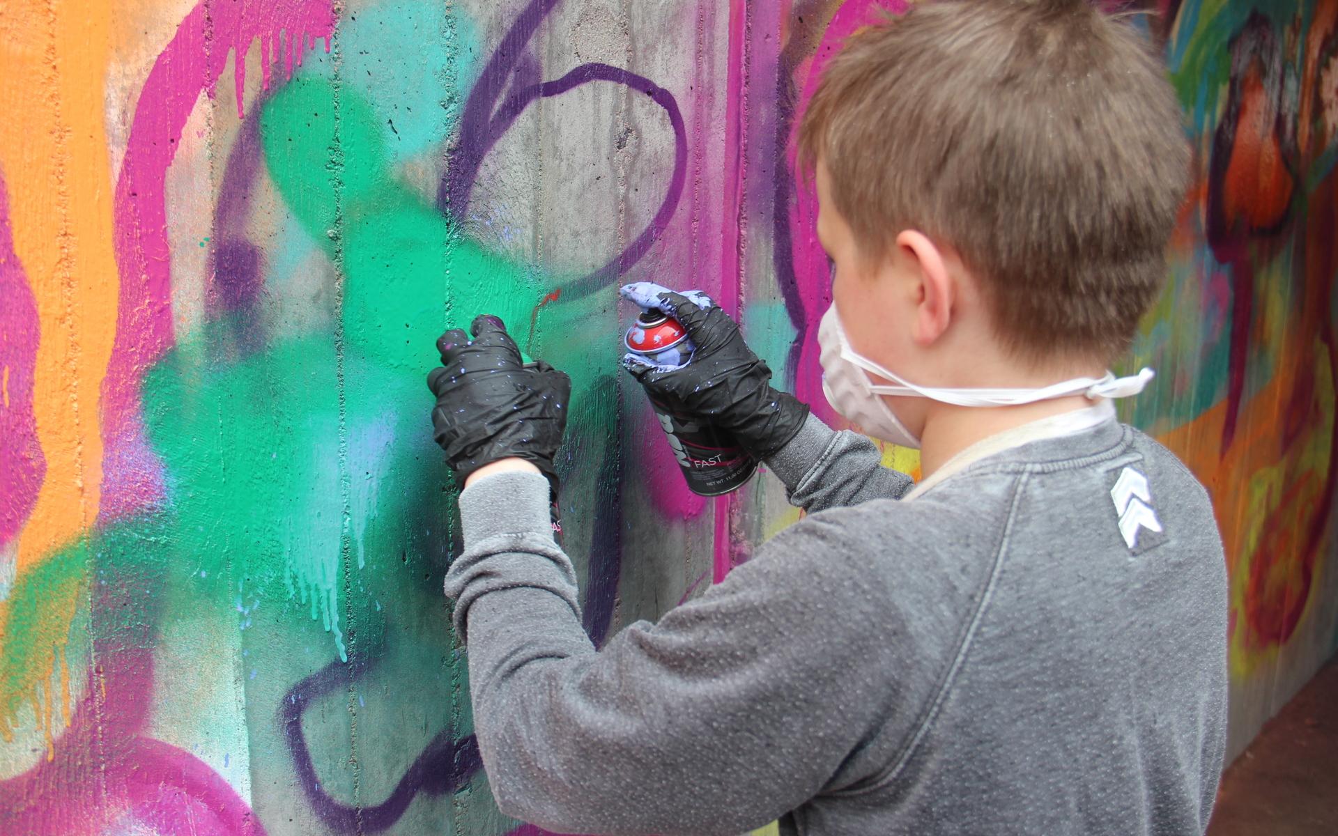 William provar tekniken med att hålla en sprayburk i varje hand.